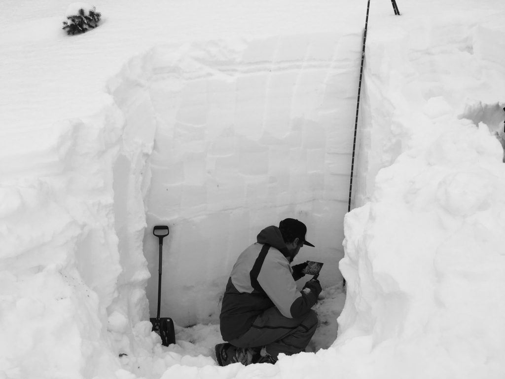 Digging for snow pits to test stability for avalanche.