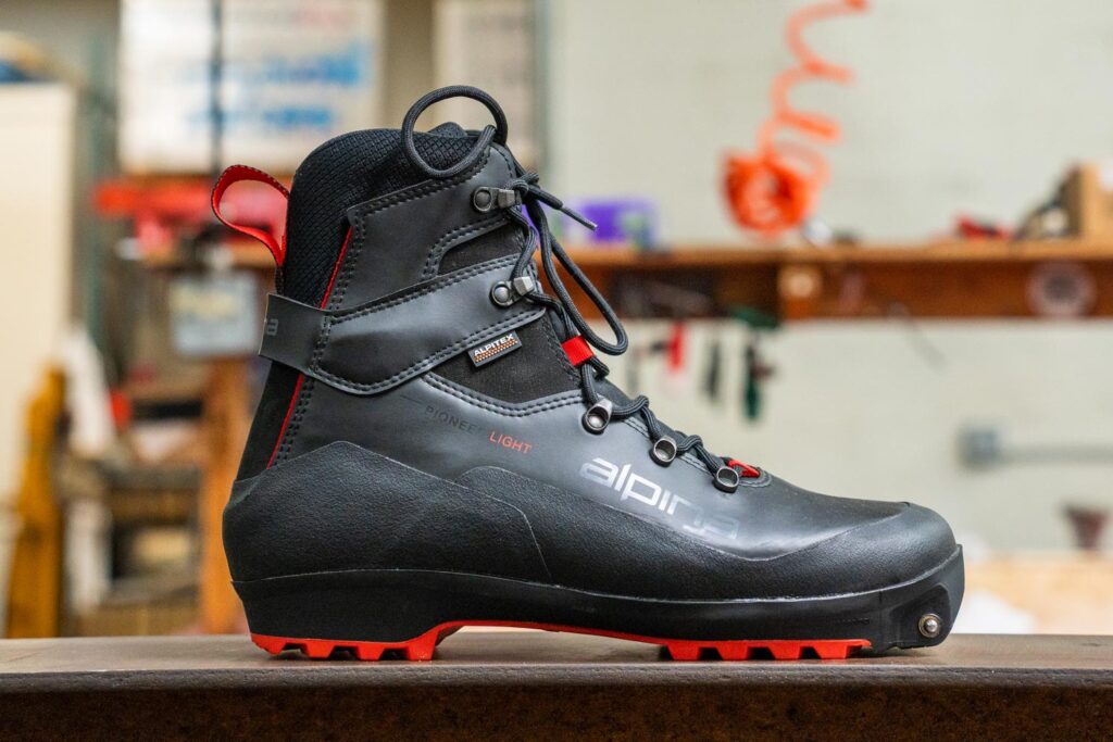 Alpina Pioneer Light XP boot showing its synthetic upper, lacing system, and Xplore-compatible sole.