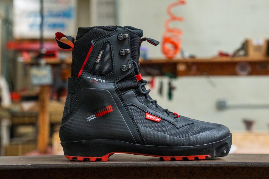 Alpina Pioneer Tech XP boot showing its synthetic upper, reinforced cuff, and Xplore-compatible sole.