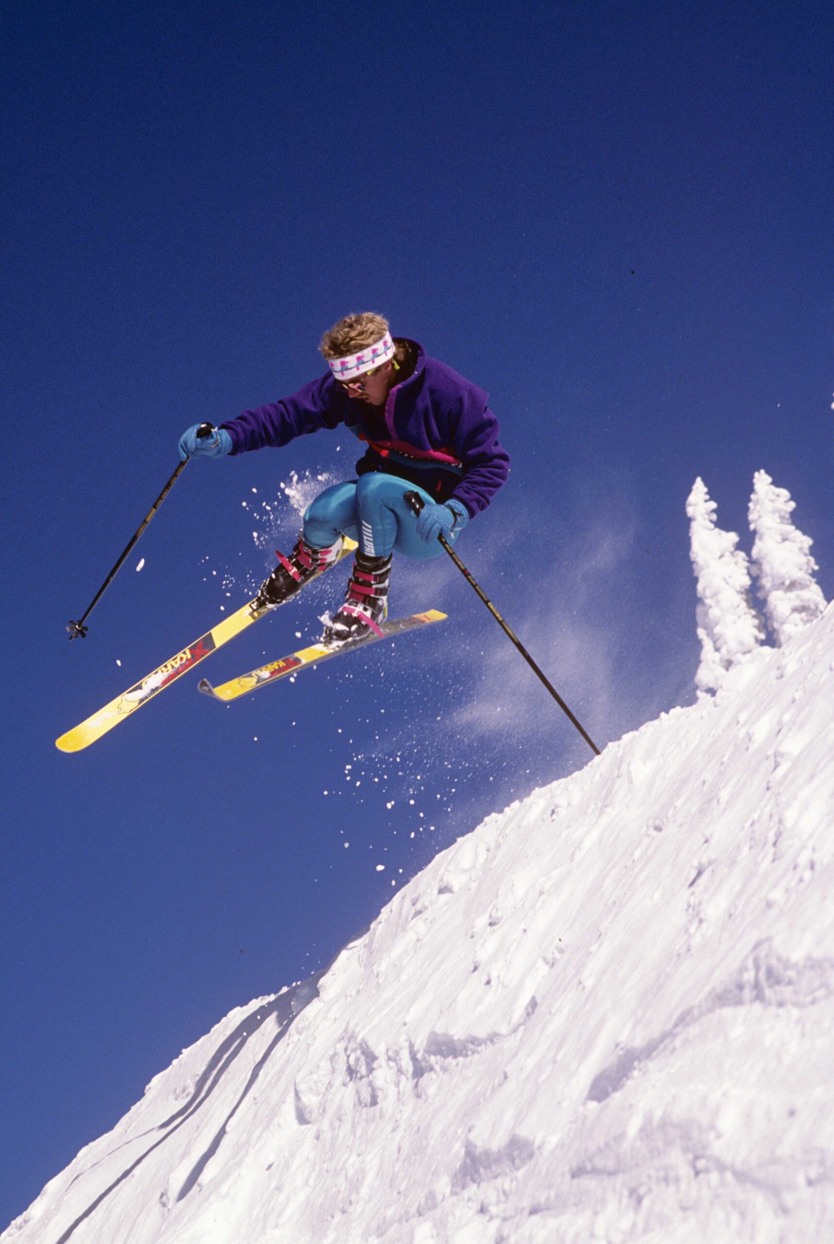 Film photo of 3-pin skier in Merrell Super Comp boots making a jump in off-piste terrain.