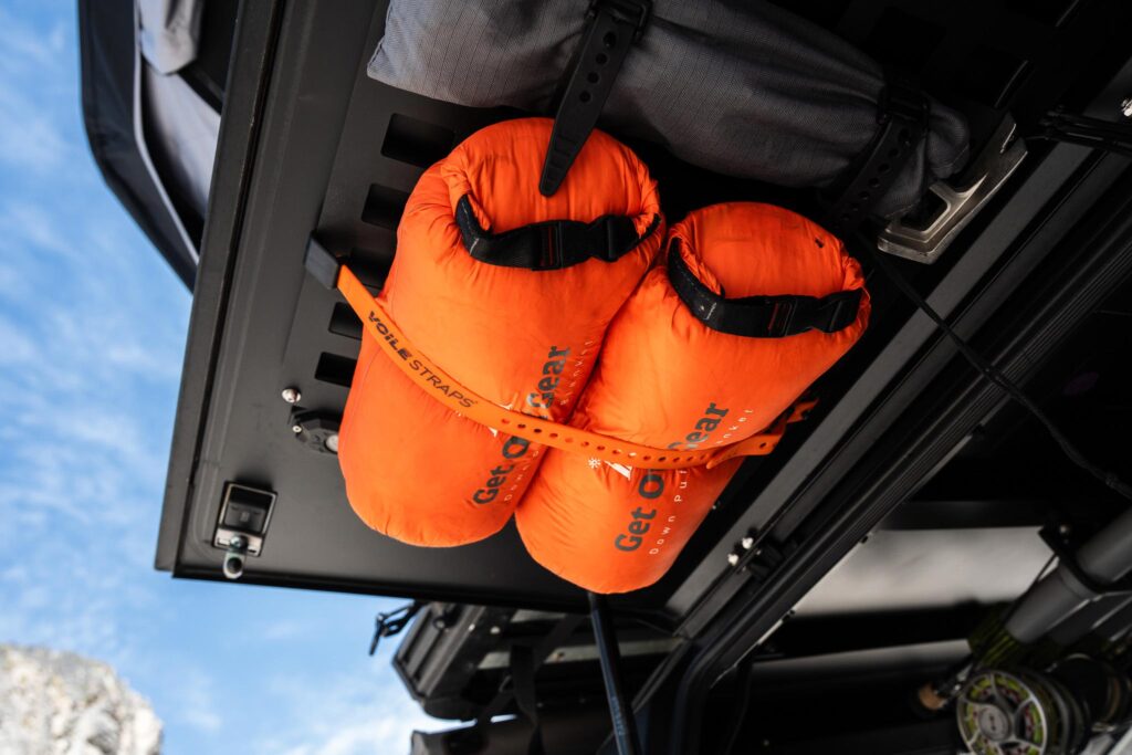 Voile Rack Straps securing two dry bags to an overlanding MOLLE panel on Ford F150 utility shell.