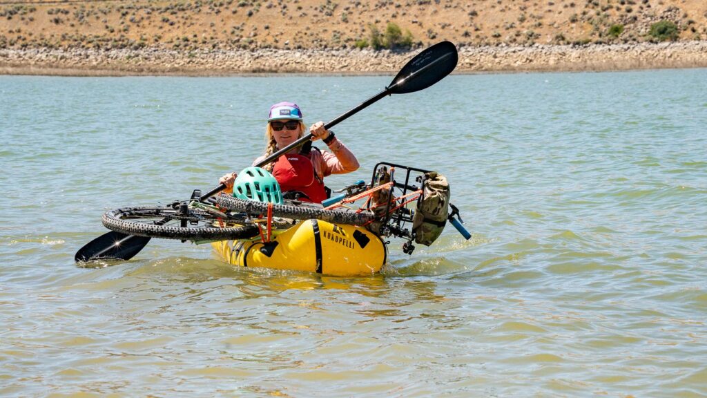 Bike secured to a packraft with Voile Straps on a windy lake.