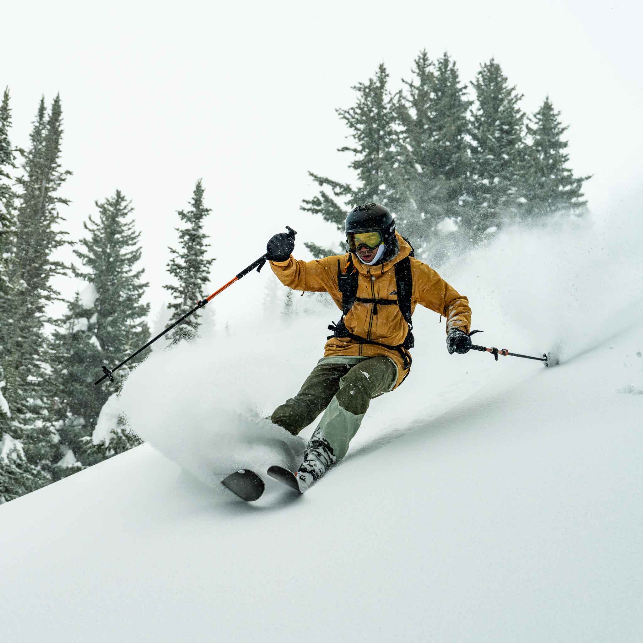 Skier turning through fresh powder on Voile Hyper Drifter skis with trees behind