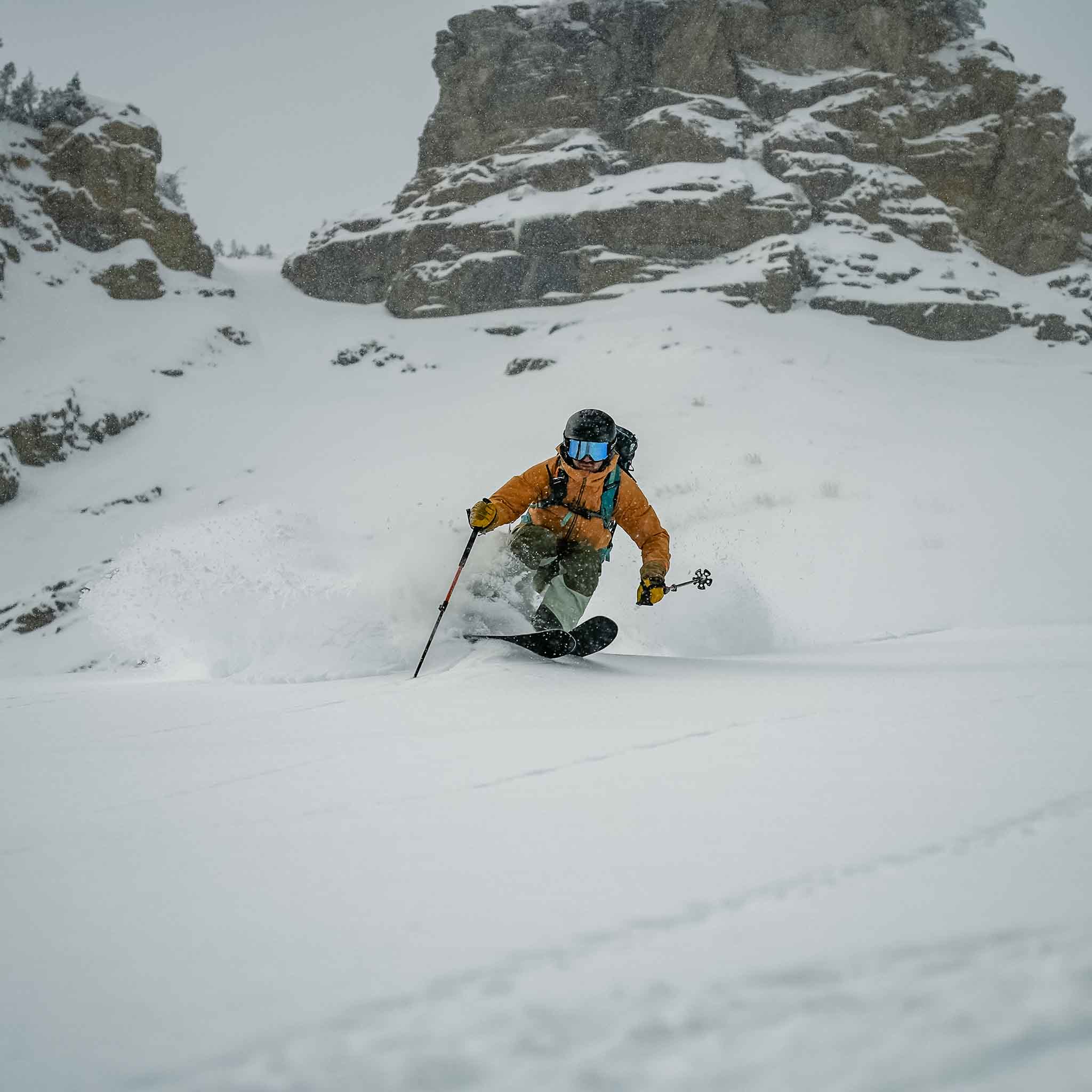 Skier dropping into terrain on Voile Hyper Drifter skis with rock outcroppings