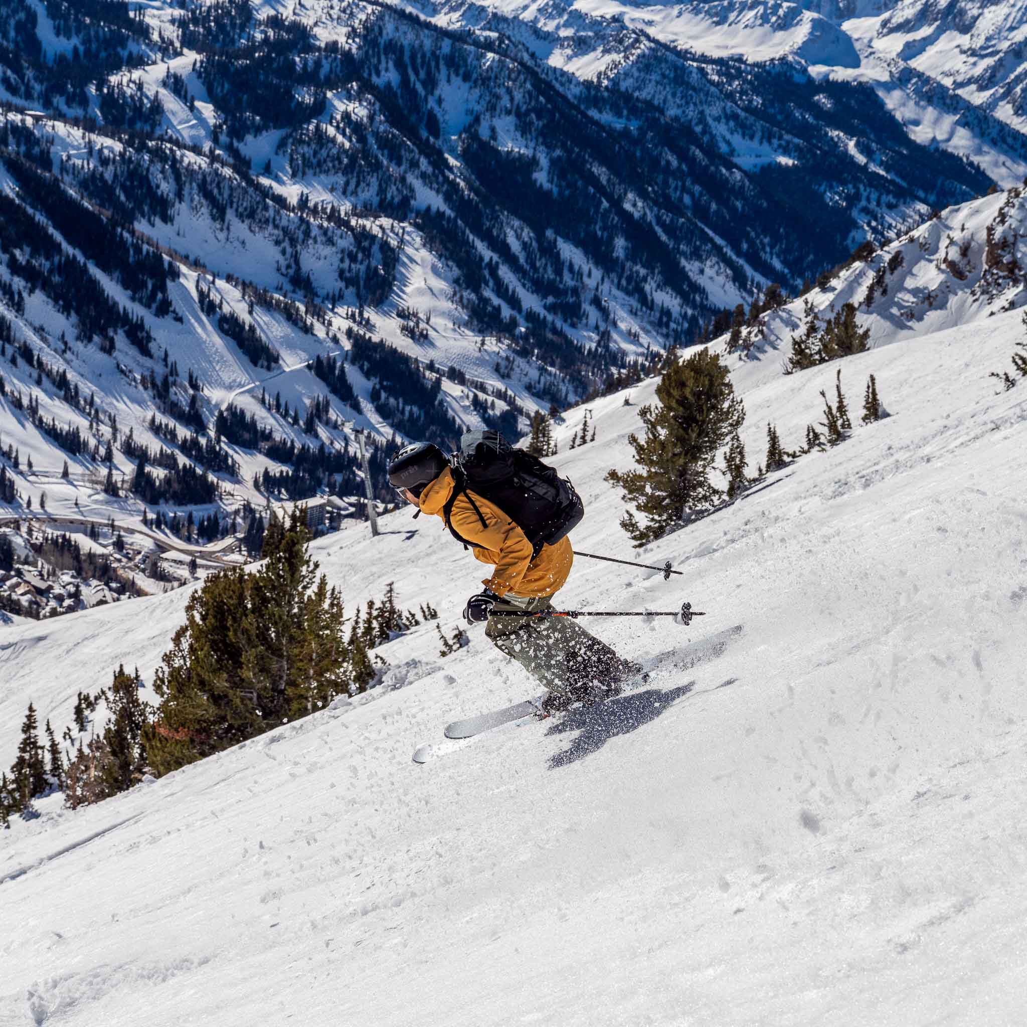 Skier carving on Voile Hyper Manti skis with valley and trees in background