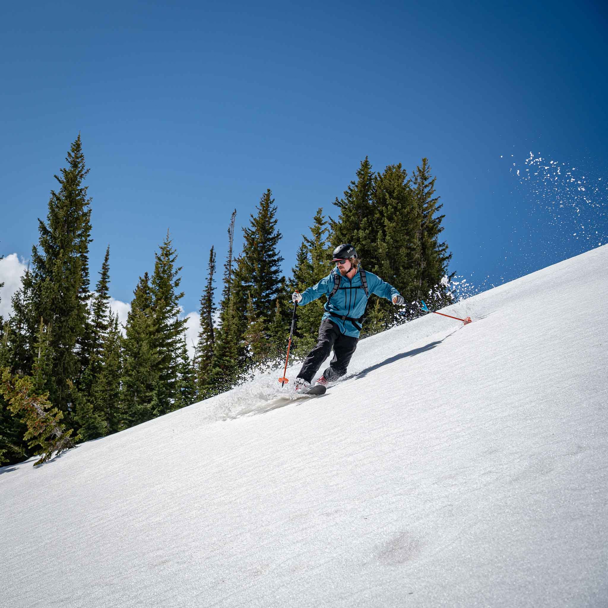 Skier carving a turn through snowy trees on Voile Vector ACE skis